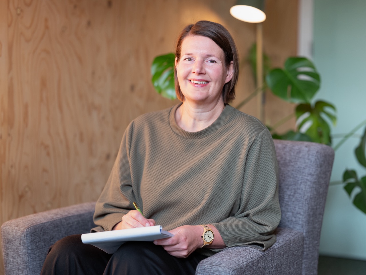 slaapcoach Tessa Dekkers in praktijk op stoel met blocnote en pen.